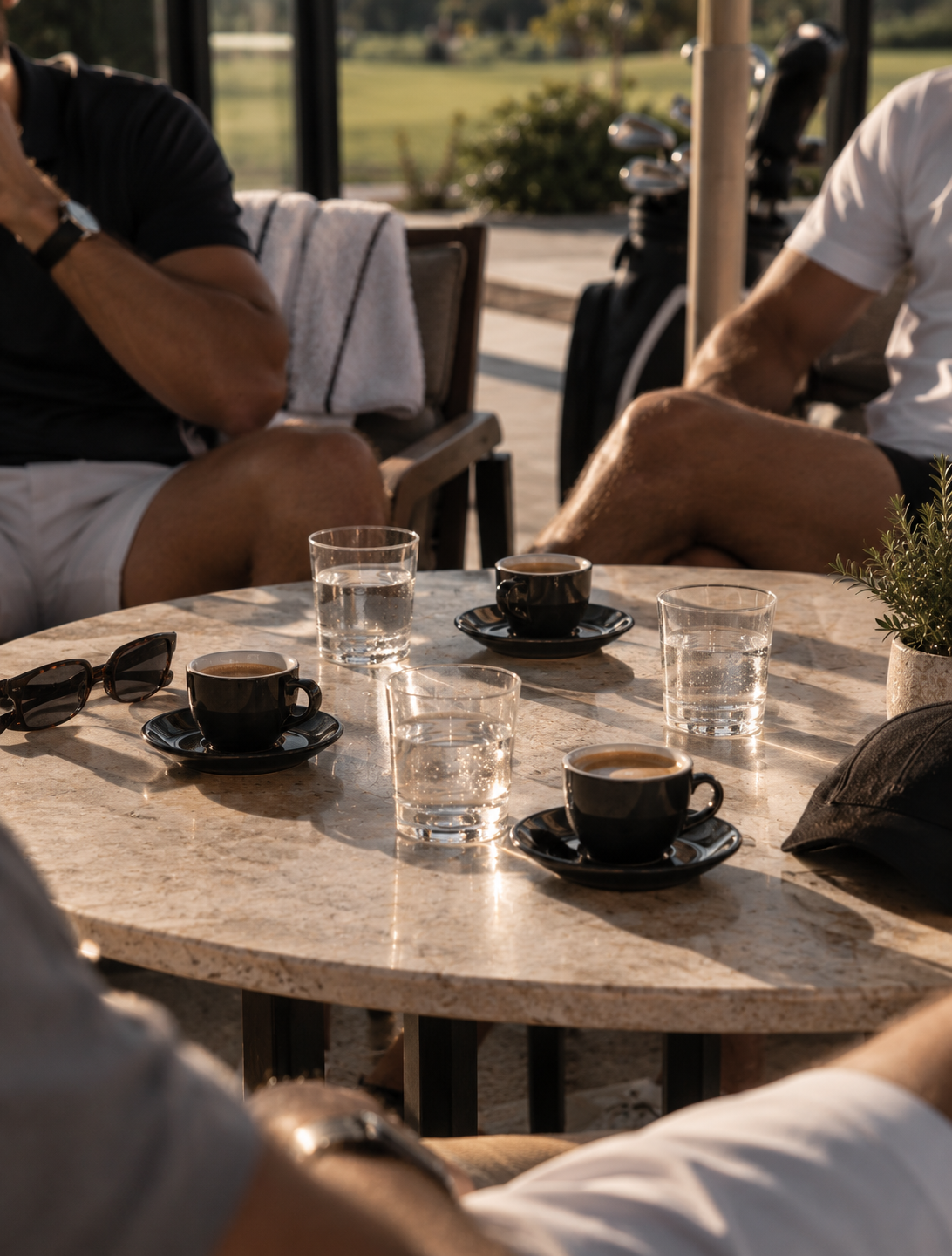 Espresso cups and sunglasses on a marble café table